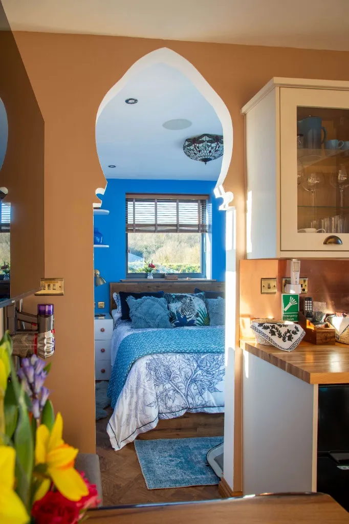 Decorative archway from the kitchen through to a blue bedroom at an Enchanted Lodge, Woodhill Weddings, Faversham, Kent