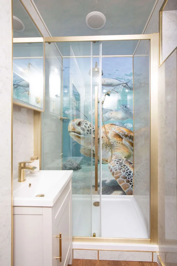 Marble-effect bathroom with a glass shower at an Enchanted Lodge, Woodhill Weddings, Faversham, Kent