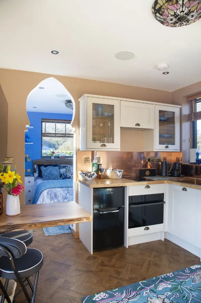 Kitchen and dining space with a copper splashback at an Enchanted Lodge, Woodhill Weddings, Faversham, Kent