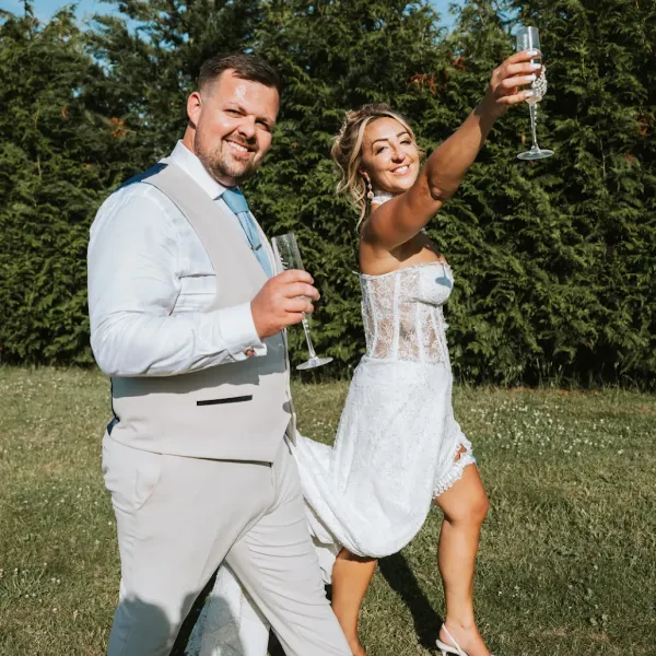 A bride and groom raising a champagne toast in the grounds