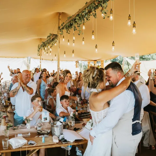 Newlyweds celebrating their first dance under the stretch tent